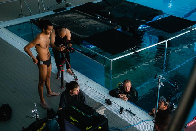 Photo d'un tournage de film autour d'une piscine intérieure