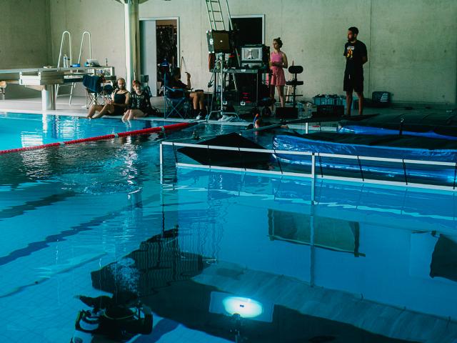 Photo d'un tournage de film autour d'une piscine intérieure