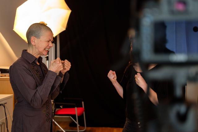 L'artiste Cristina Nuñez dans son studio photo en train de portraiter une femme qu'on voit de dos