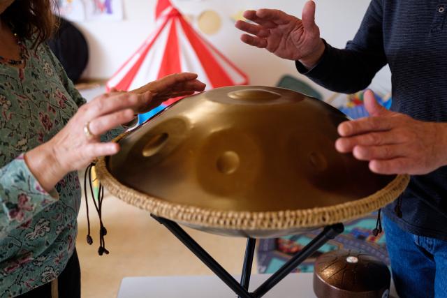 Hands of two people playing a cymbal