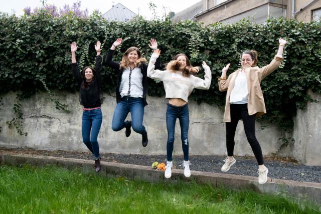 4 femmes dans un jardin qui sautent en l'air