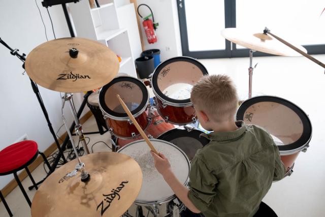 un jeune garçon joue sur une batterie